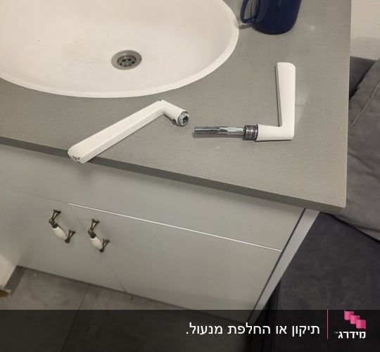 כיור עם ידיות שבורות על השיש